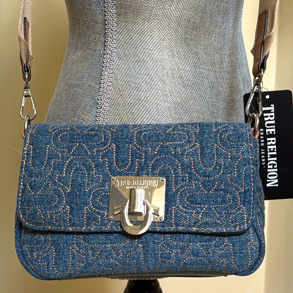 True Religion Denim Crossbody Bag. Tan strap with True Religion writing.